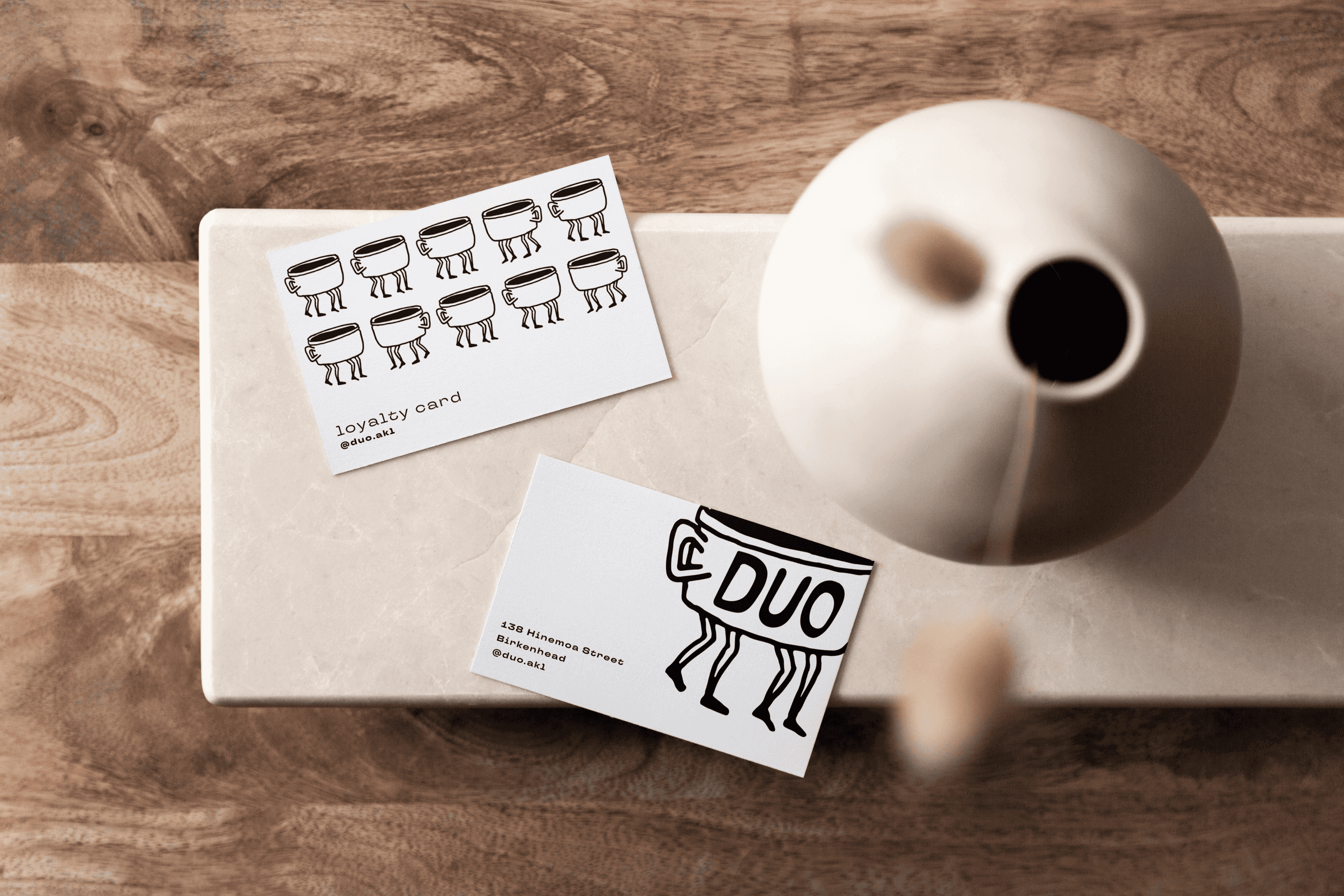 Duo coffee cards next to a cute vase