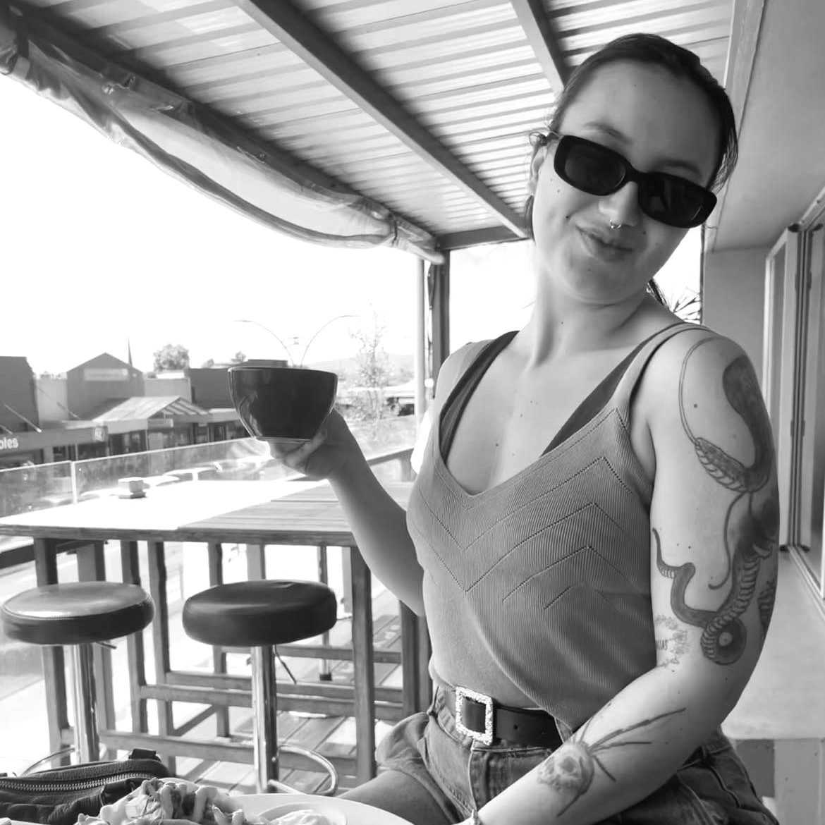 Kaycee with a coffee in hand and sunglasses on